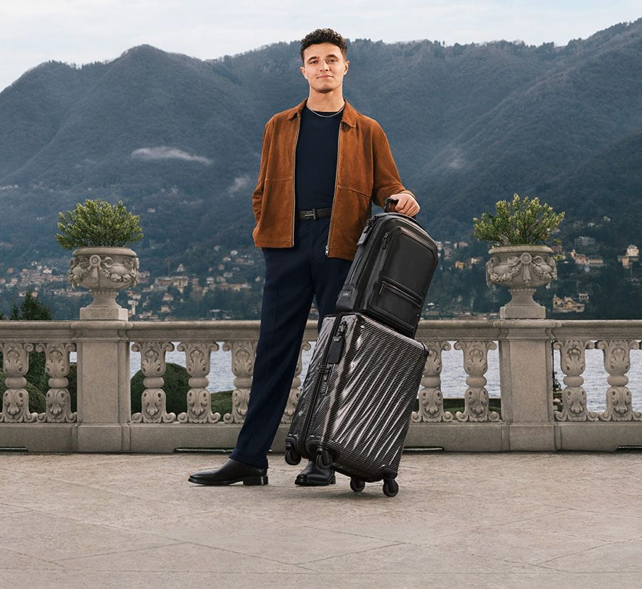 Imagen de gombre con ropa y maletas negras. TUMI