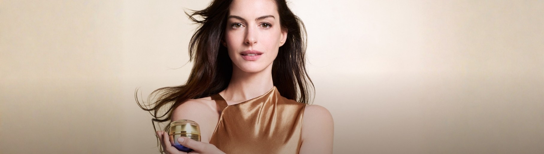 Imagen de mujer con frasco de tratamiento color dorado SHISEIDO