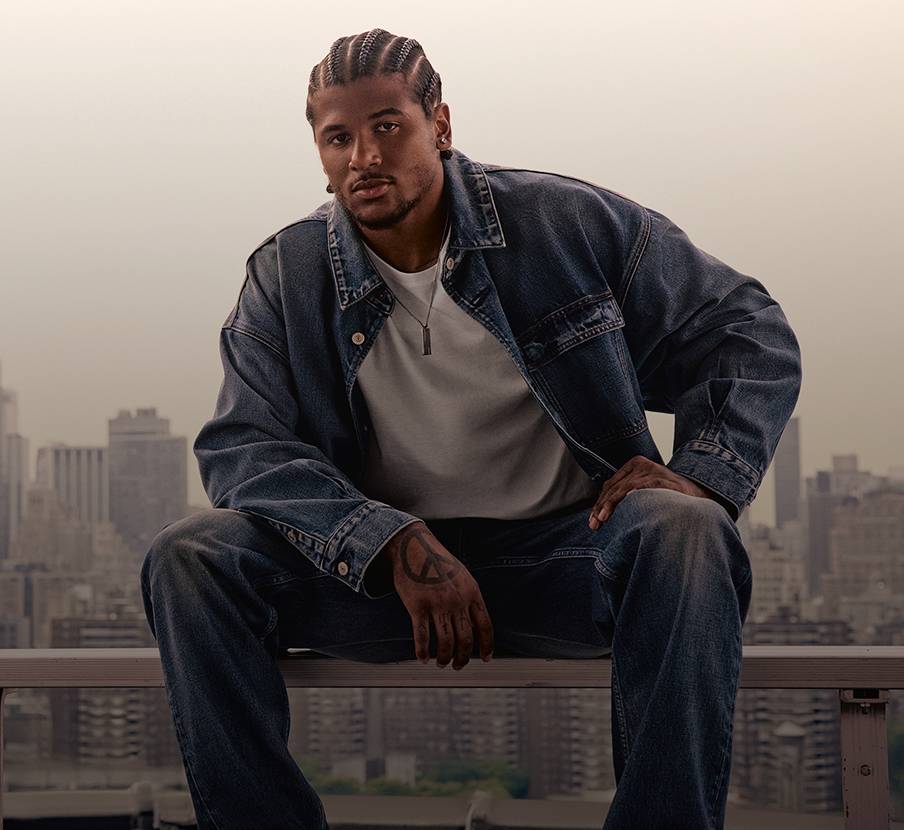 Imagen de hombre con chamarra y pantalon azul de mezcliya y playera blanca CLAVIN KLEIN