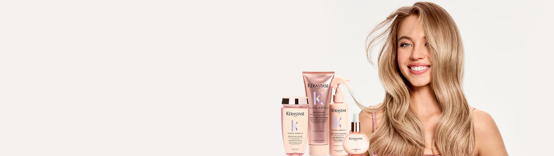 imagen de mujer junto a set de tratamiento color lila de la marca KERASTASE