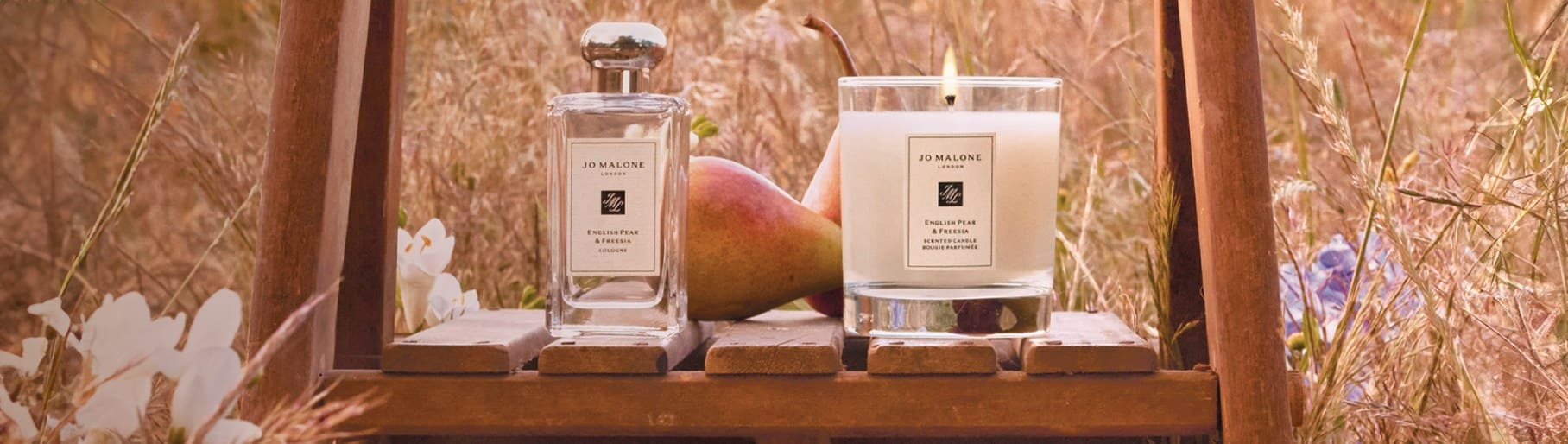 Imagen de un frasco locion junto a veladora de la marca JO MALONE LONDON.