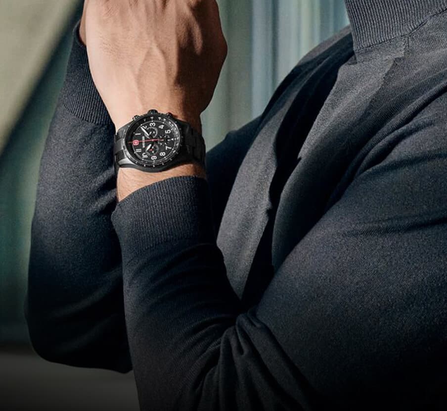 Imagen de un hombre al que se le ve solo el troso, lleva un reloj color negro de la marca WENGER