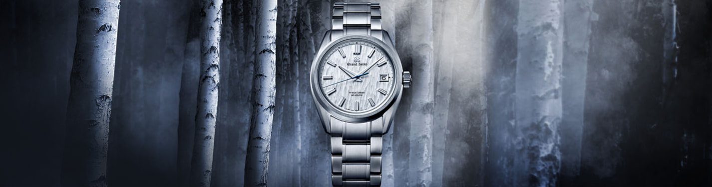 reloj plateado de la marca SEIKO, con un fondo de bosques de abedules blancos de noche