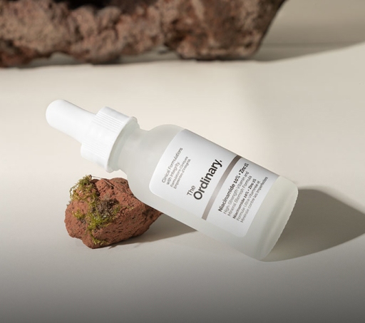 Imagen de un frasco con gotero  de la marca THE ORDINARY, sobre una piedra. CLEAN & GREEN