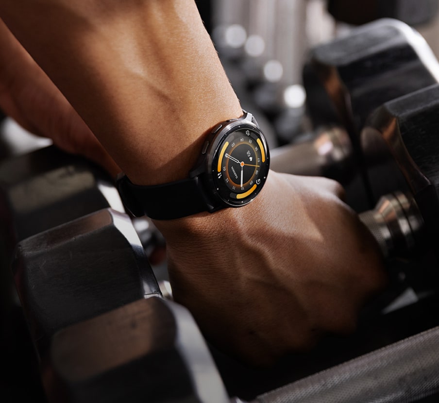 imagen de manos tomamdo manciernas llevan un raloj negro con amarillo en la muñeca, GARMIN
