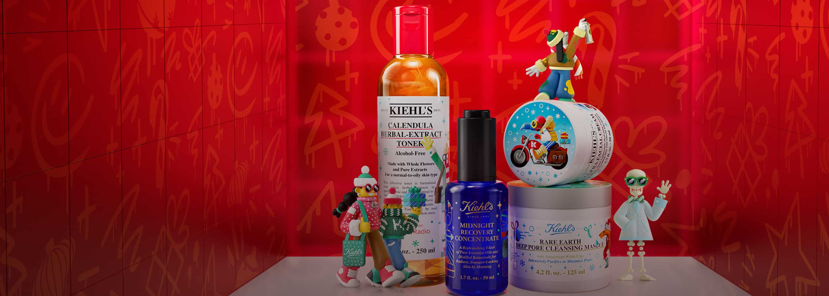 Imagen de cuatro productos de a marca KIEHLS, en un entorno navideño con adornos y fugurillas. KIEHL'S