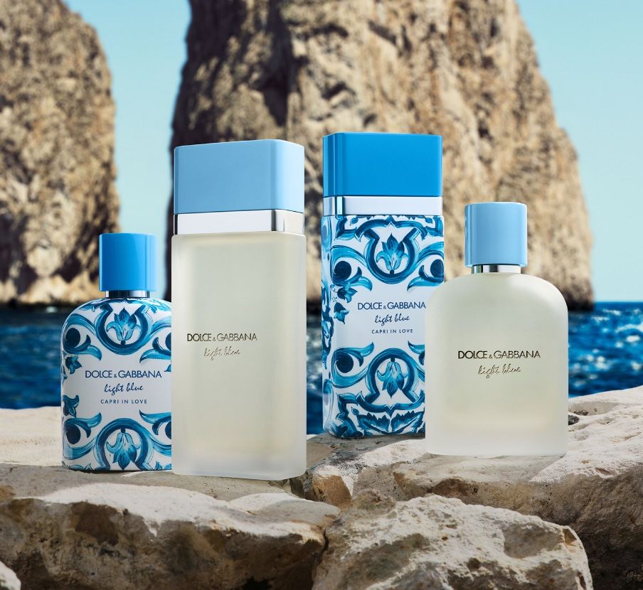 imagen de una una pieda en la playa en la cual hay 4 frascos de perfume de la marca DOLCE&GABBANA  