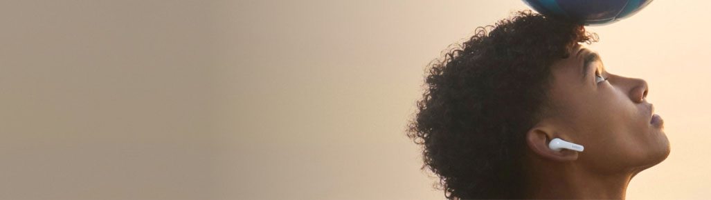 hombre dominande un balon con la cabeza llevando audifonos blancos in alambricos de la marca BELKIN