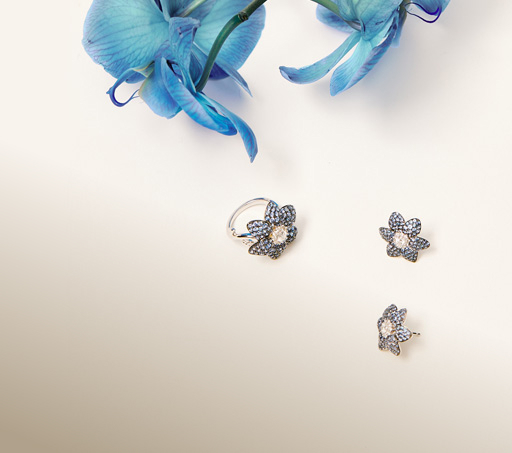 imagen de un anillo y aretes en forma de flor con piedras blillantes. SUAREZ
