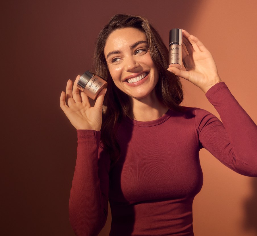 Imagen de mujer con dos frascos de bases de maquillaje de la marca NATURA BISSÉ