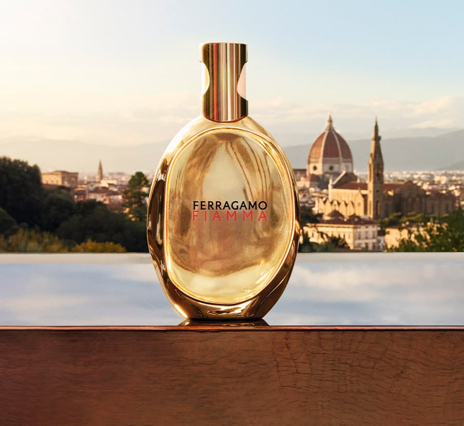 Imagen de botella dorada de locion junto aun rio de la marca FERRAGAMO