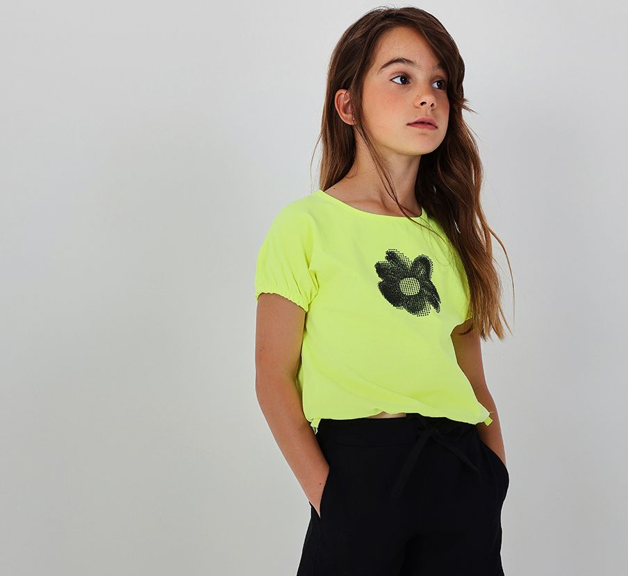 Imagen de un niña con blusa verde y pantalon negro de la marca BOBOLI