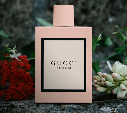 Botella rosa de perfume con etiqueta blanca, Gucci BLOOM. GUCCI