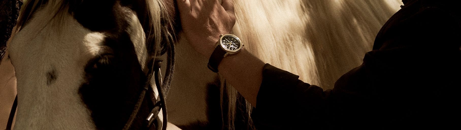 imagen de hombre con un caballa y reloj de la marca INGERSOLL