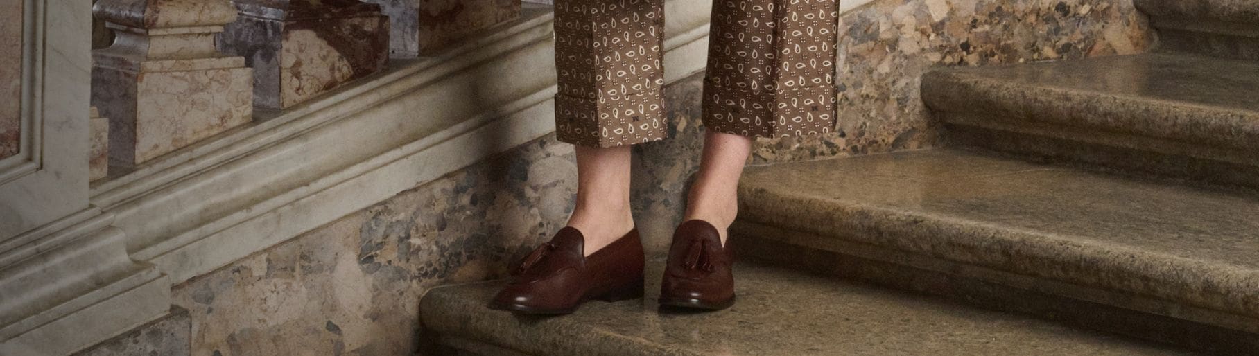 Imagen de los pies de una mujer usando zapatos color cafes de la marca MAX MARA