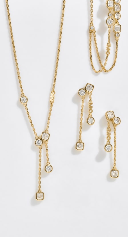 imagen de un conjunto de collar, pulsera y arestes de oro con piedras brillantes, MICHAEL KORS