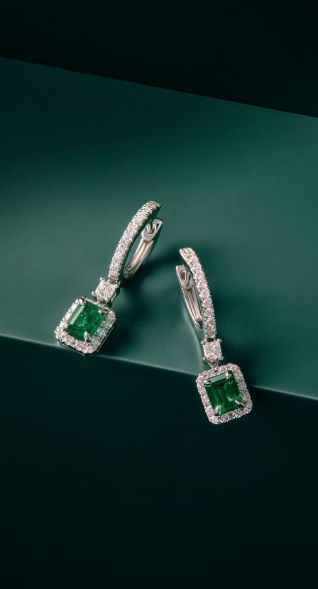 imagen de par de aretes plateados con verde SUAREZ