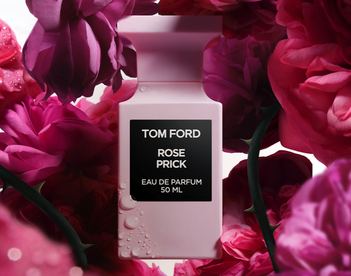 Imagen de un frasco de perfume rosa Rose Prick de la marca TOM FORD sobre pétalos de rosas. TOM FORD