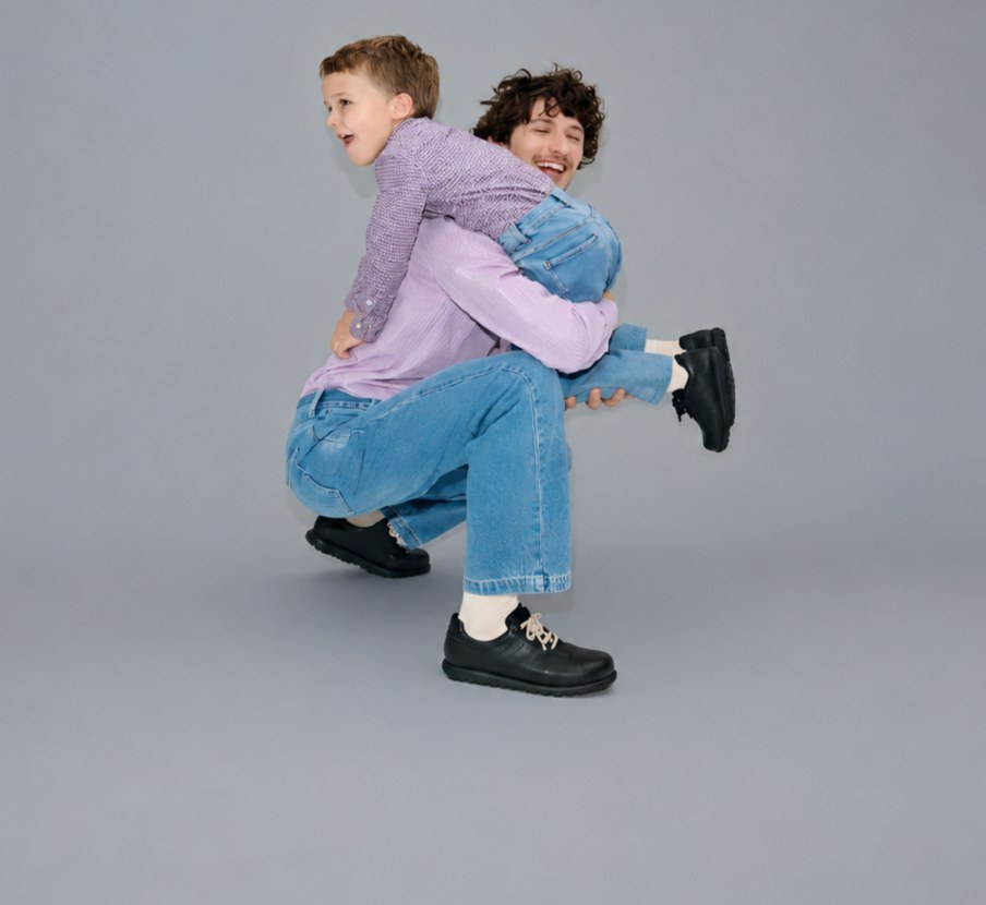 Imagen de hombre cargando a niño de la marca Camper