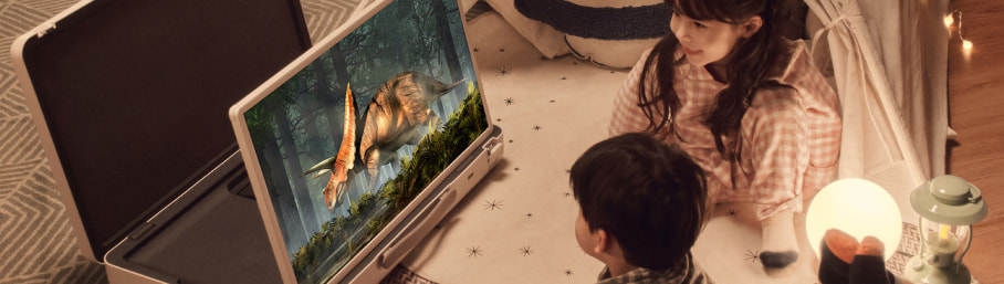 Imagen de par de niños viendo pantalla con un dinosaurio