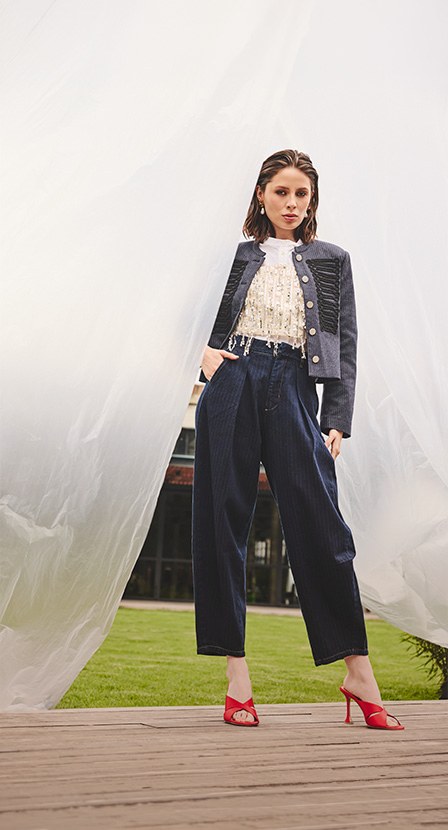 imagen de mujer con gabardina negra y pantalon azul